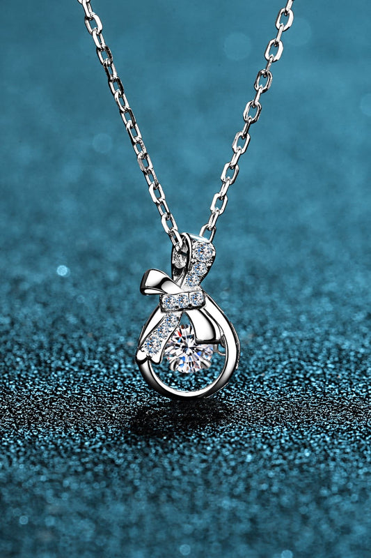 Elegant silver pendant necklace featuring a round diamond encircled by bow-like design - silver / one size