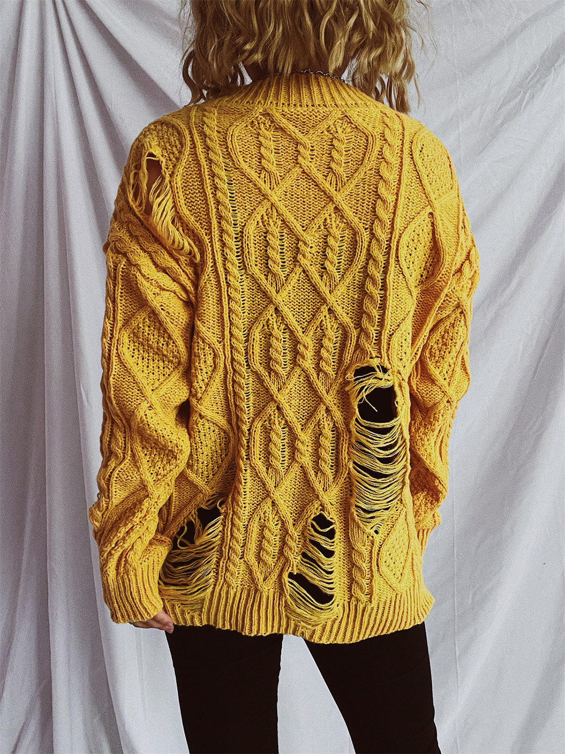 Distressed cable-knit round neck long sleeve sweater