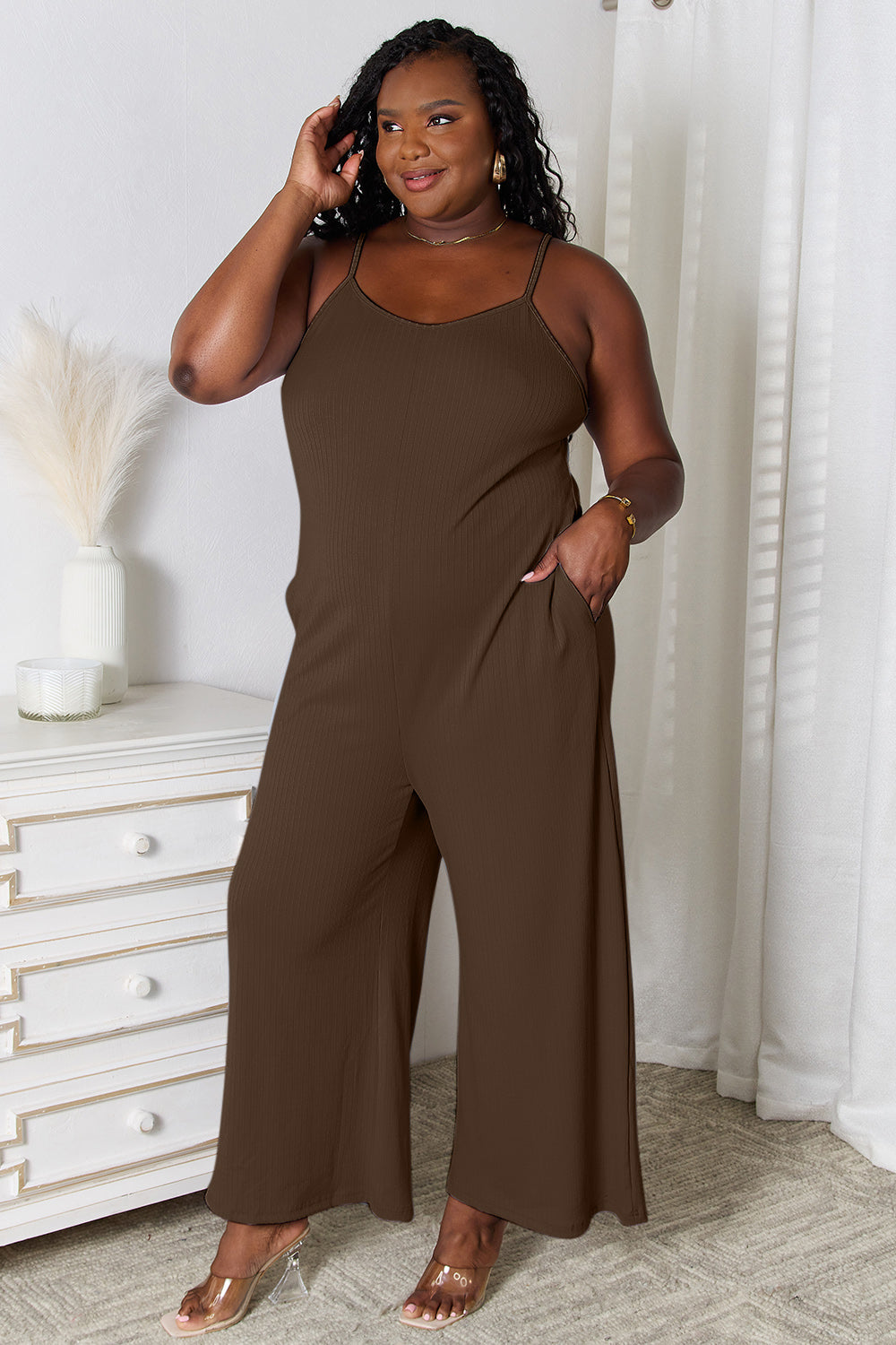 Woman wearing a brown sleeveless jumpsuit with wide-leg pants.