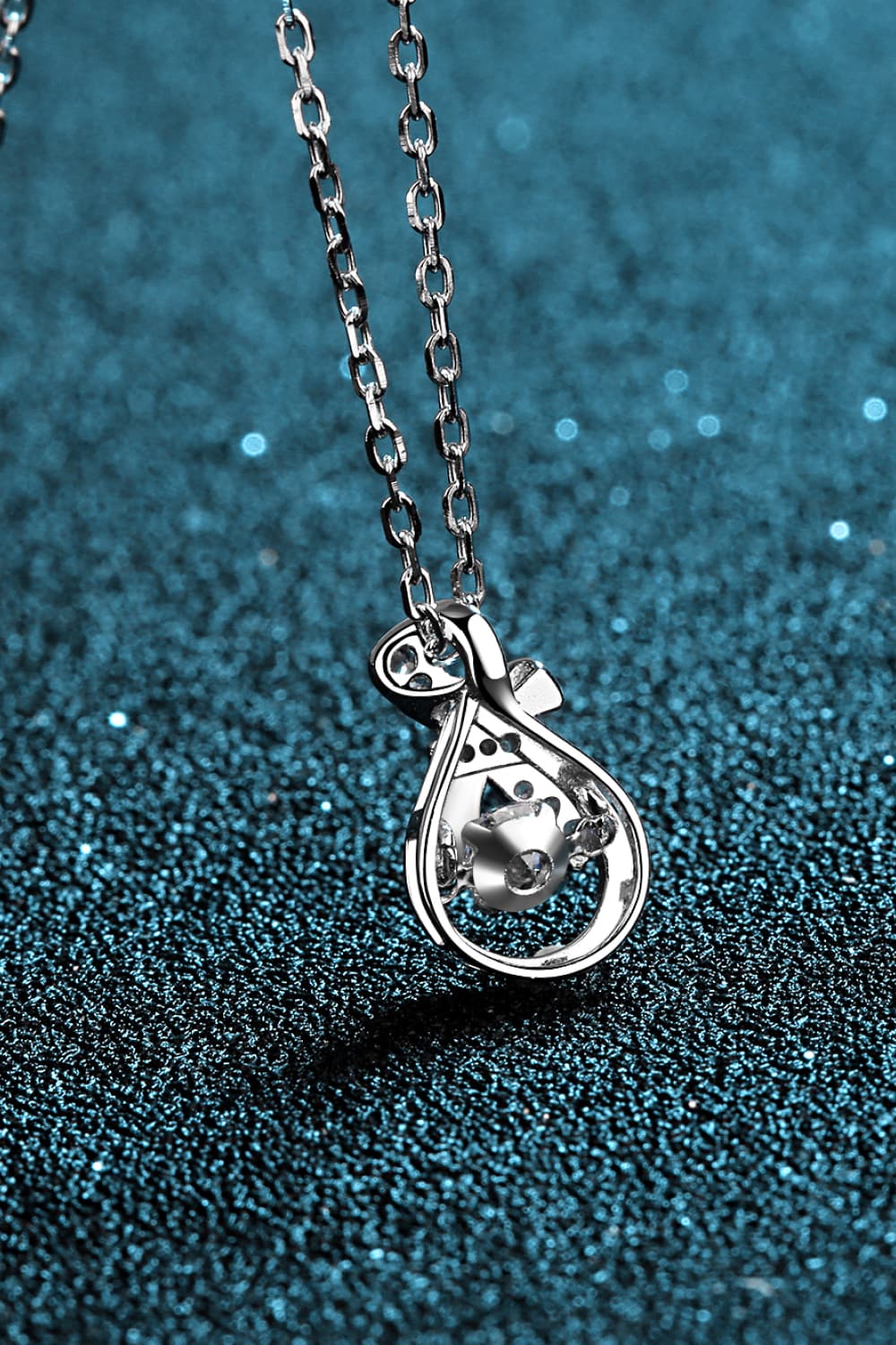 Elegant silver pendant necklace featuring a round diamond encircled by bow-like design - silver / one size