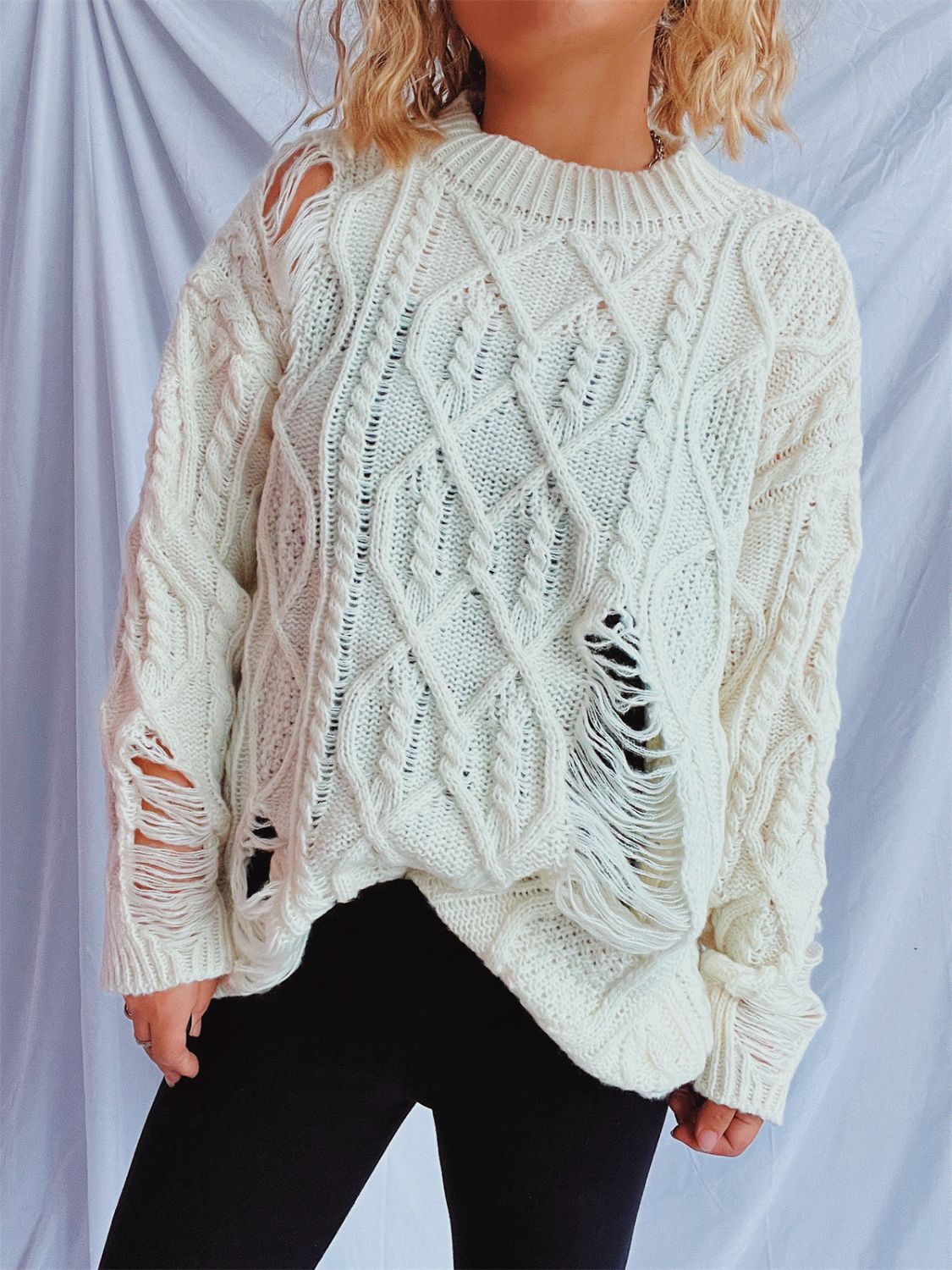 Distressed cable-knit round neck long sleeve sweater