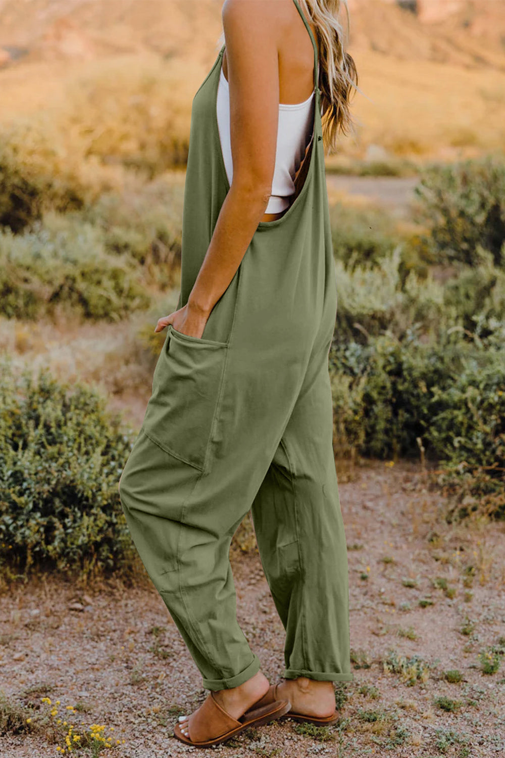 Green sleeveless jumpsuit with wide legs and pockets.