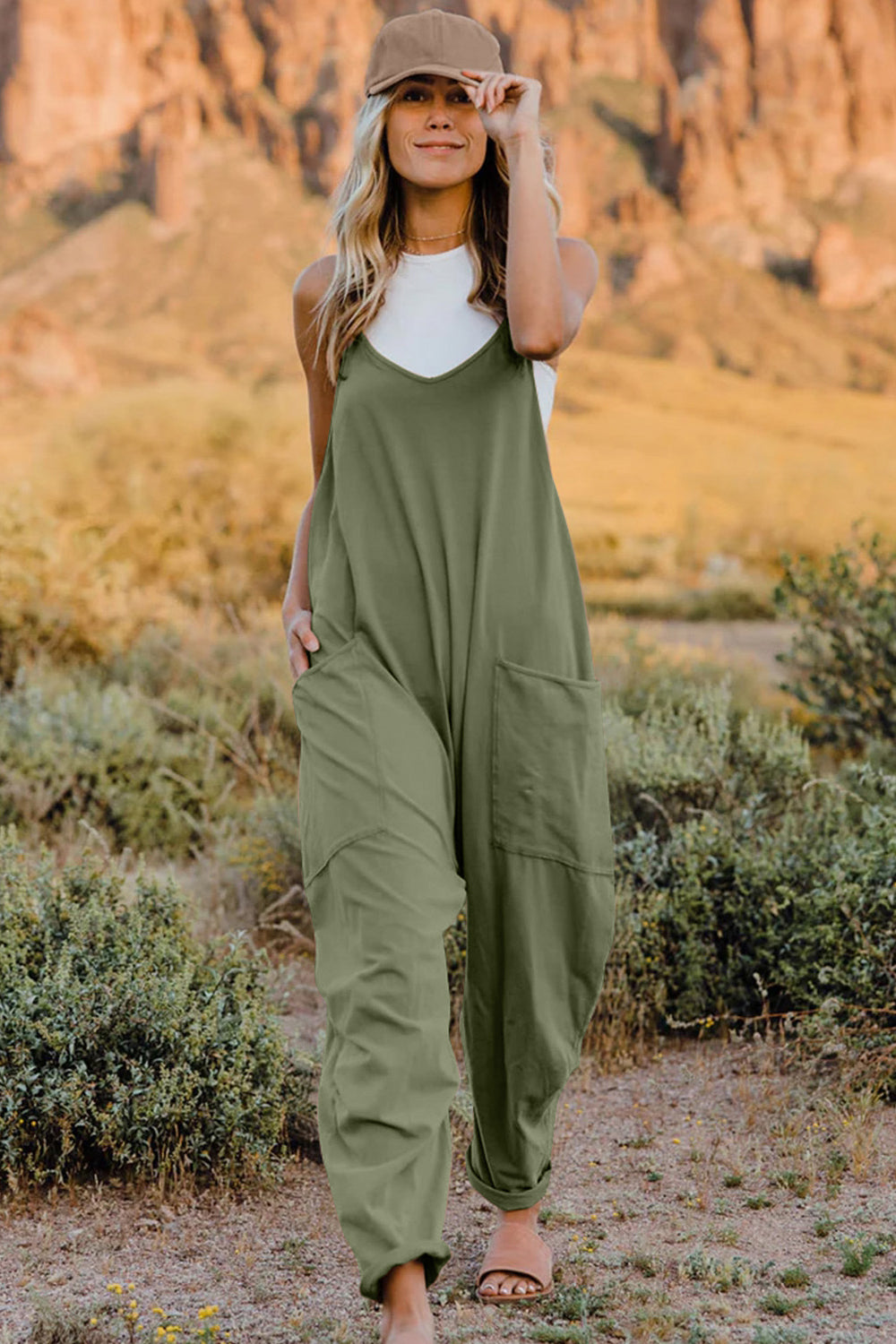 Olive green loose-fitting jumpsuit with wide legs and pockets.