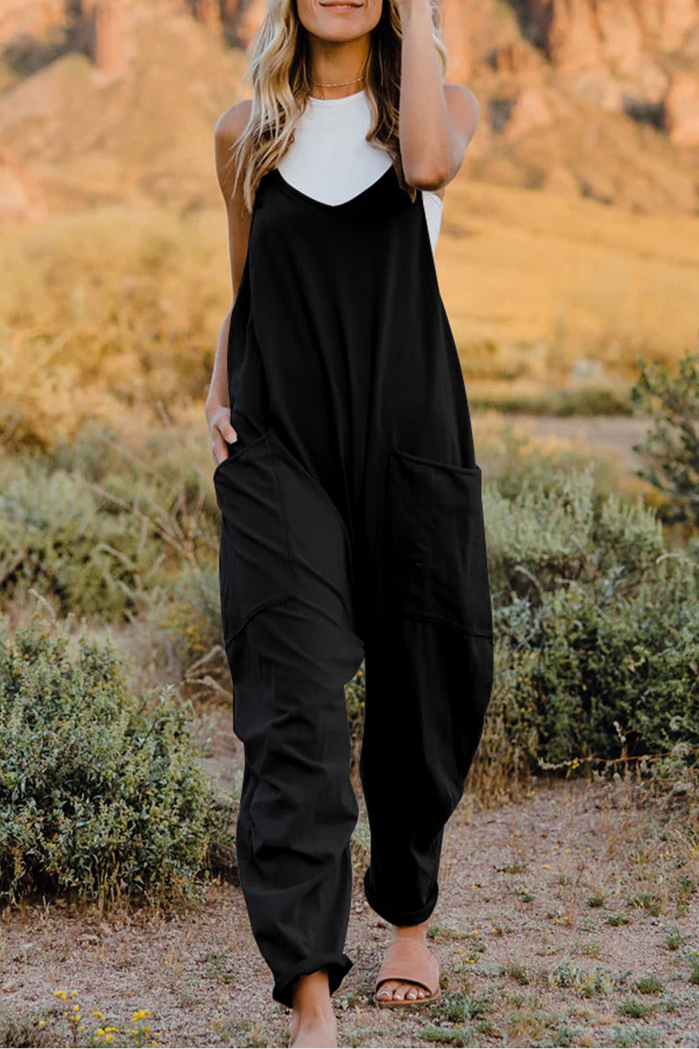 Black loose-fitting jumpsuit or overalls worn over a white top.